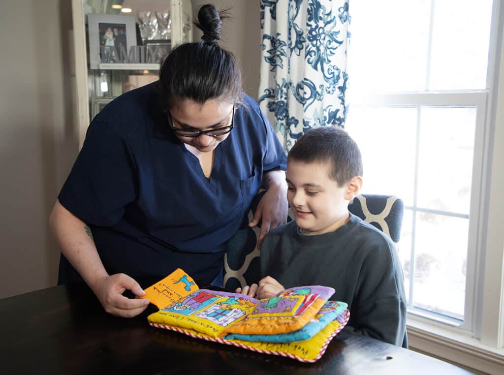 Child with special needs doing a learning activity with a Caretech caregiver